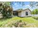 Backyard with grass and view of screened in patio and a partial view of the side yard at 5115 Stonehaven Ct, Tampa, FL 33624