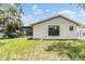 Exterior view of home's backyard featuring ample grass, a rear side window, and the home's siding at 5115 Stonehaven Ct, Tampa, FL 33624