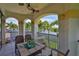 Balcony with tile floors, table set for four, and a view of the waterfront surrounded by palm trees at 5417 Tybee Island Dr, Apollo Beach, FL 33572