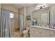 Comfortable bathroom with a walk-in shower, light fixtures, white cabinets, and tile flooring at 5417 Tybee Island Dr, Apollo Beach, FL 33572