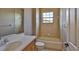 Bright bathroom featuring a vanity sink, bath tub, large window, and neutral tiling at 5417 Tybee Island Dr, Apollo Beach, FL 33572