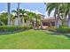 Attractive home with meticulously maintained lawn, mature landscaping, and a circular driveway with a central fountain at 5417 Tybee Island Dr, Apollo Beach, FL 33572