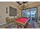 Elegant game room with a billiard table, ornate chandelier, and outdoor views at 5417 Tybee Island Dr, Apollo Beach, FL 33572