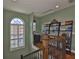 Upstairs landing featuring a bookshelf, natural lighting from an arched window, and hardwood floors at 5417 Tybee Island Dr, Apollo Beach, FL 33572