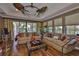 Spacious living room features a tray ceiling, ceiling fans, large windows, hardwood floors, and comfortable seating at 5417 Tybee Island Dr, Apollo Beach, FL 33572