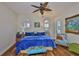 Charming bedroom with a plush blue bed, bright windows, hardwood floors, and unique décor at 5417 Tybee Island Dr, Apollo Beach, FL 33572