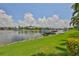 View of waterfront docks and manicured lawn leading to water at 5417 Tybee Island Dr, Apollo Beach, FL 33572