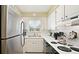Clean and organized kitchen with black appliances, light countertops, and natural light at 600 71St Ave # 16, St Pete Beach, FL 33706