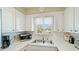 Bright kitchen area with white cabinets, ample counter space, and a window for natural light at 600 71St Ave # 16, St Pete Beach, FL 33706