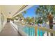 Balcony view of a refreshing community pool surrounded by tropical palm trees at 600 71St Ave # 16, St Pete Beach, FL 33706