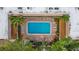 Aerial shot of a community pool surrounded by palm trees and lounge chairs at 600 71St Ave # 16, St Pete Beach, FL 33706