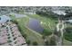 Picturesque aerial view of homes nestled alongside a scenic golf course and tranquil lake at 611 Tremont Greens Ln, Sun City Center, FL 33573