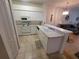 Well-lit kitchen featuring tile floors, modern white cabinets, and a breakfast bar overlooking the living area at 611 Tremont Greens Ln, Sun City Center, FL 33573