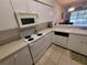 Bright kitchen features white appliances, tile floors, and easy access to the living room at 611 Tremont Greens Ln, Sun City Center, FL 33573