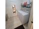 A functional laundry room with tile floors, a utility sink and a front loading washer and dryer at 611 Tremont Greens Ln, Sun City Center, FL 33573