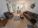 Spacious living room featuring hardwood floors, a comfortable seating arrangement, and open access to other living areas at 611 Tremont Greens Ln, Sun City Center, FL 33573