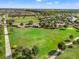 Overhead view of a community green space with a walking path and playground near a lake at 6123 Golden Nettle Dr, Apollo Beach, FL 33572
