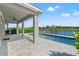 Outdoor living space with covered patio overlooking the pool and scenic lake views under a clear sky at 6123 Golden Nettle Dr, Apollo Beach, FL 33572