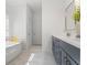 Bright bathroom has a double sink vanity, soaking tub, and white marble floors at 6123 Golden Nettle Dr, Apollo Beach, FL 33572