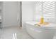 Bright bathroom features a soaking tub near the window and a glass-enclosed shower at 6123 Golden Nettle Dr, Apollo Beach, FL 33572