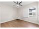 Well-lit bedroom features a ceiling fan, hardwood floors and window with exterior view creating a serene retreat at 6123 Golden Nettle Dr, Apollo Beach, FL 33572
