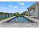 Relaxing in-ground pool with stunning lake views, ideal for summer enjoyment and outdoor entertainment at 6123 Golden Nettle Dr, Apollo Beach, FL 33572