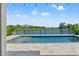 Beautiful in-ground pool featuring lake views, complemented by an extended patio for ultimate relaxation at 6123 Golden Nettle Dr, Apollo Beach, FL 33572