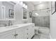 Modern bathroom with dual sinks, white cabinets, and a glass-enclosed shower over tub at 613 Sportsman Park Dr, Seffner, FL 33584