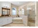 Bright bathroom featuring a glass enclosed shower and a soaking tub under an arched window at 613 Sportsman Park Dr, Seffner, FL 33584
