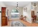 Bright dining room featuring a large arched window, wood floors, and a vintage cabinet at 613 Sportsman Park Dr, Seffner, FL 33584