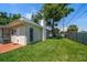 Fenced backyard features a lush lawn, mature trees, and additional storage at 6282 41St N Ave, St Petersburg, FL 33709