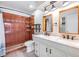 Bathroom featuring double sink vanity, tile flooring, and tiled walk-in shower at 660 Channing Dr, Palm Harbor, FL 34684