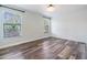 Bedroom with wood flooring, light-green accent wall, and two windows at 660 Channing Dr, Palm Harbor, FL 34684