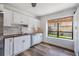 Bright kitchen featuring white cabinets, stainless appliances, wood floors, and a garden view window at 660 Channing Dr, Palm Harbor, FL 34684