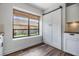 Bright kitchen featuring white cabinets, stainless appliances, wood floors, and a sliding barn door at 660 Channing Dr, Palm Harbor, FL 34684