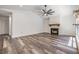 Bright living room with a vaulted ceiling, a modern ceiling fan, and a cozy fireplace with wood-look floors at 660 Channing Dr, Palm Harbor, FL 34684