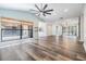 Open-concept living area featuring wood-look floors, lots of natural light, a modern ceiling fan, and a spacious feel at 660 Channing Dr, Palm Harbor, FL 34684