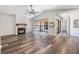 Spacious living room with a fireplace, high ceilings, wood-look flooring, and natural light streaming through a large window at 660 Channing Dr, Palm Harbor, FL 34684