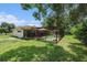 Backyard with lawn, mature trees, and screened patio and pool area at 7700 Willow Brook Ct, Hudson, FL 34667