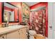 Vibrant bathroom with red walls, decorative tapestry, and a shower with patterned curtain at 7700 Willow Brook Ct, Hudson, FL 34667