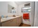 Bathroom featuring double sinks, a large mirror, and orange towels for a pop of color at 7700 Willow Brook Ct, Hudson, FL 34667