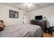 Bedroom with neutral tones, a cozy bed, and a dresser with a television for relaxation at 7700 Willow Brook Ct, Hudson, FL 34667