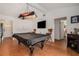 Open game room with a pool table, unique Harley Davidson lighting, and hardwood floors at 7700 Willow Brook Ct, Hudson, FL 34667