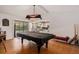 Game room with a pool table, kitchen access, and natural light creating a relaxed atmosphere at 7700 Willow Brook Ct, Hudson, FL 34667