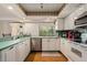 Bright kitchen featuring white cabinets, modern appliances, and a convenient breakfast bar at 7700 Willow Brook Ct, Hudson, FL 34667