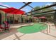 Screened-in pool with patio furniture and covered outdoor living area at 7700 Willow Brook Ct, Hudson, FL 34667