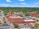 An aerial view showcases a red brick complex, lush greenery, neighborhood street, and blue skies at 909 E 15Th Ave, Tampa, FL 33605