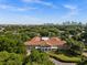 Aerial view of a large building surrounded by lush trees with the downtown skyline in the background at 909 E 15Th Ave, Tampa, FL 33605