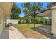 Spacious backyard with lush greenery, a covered patio and ample room for outdoor activities and relaxation at 909 E 15Th Ave, Tampa, FL 33605