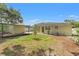 Well-maintained backyard with a wooden patio, lush lawn, and a charming home exterior at 909 E 15Th Ave, Tampa, FL 33605